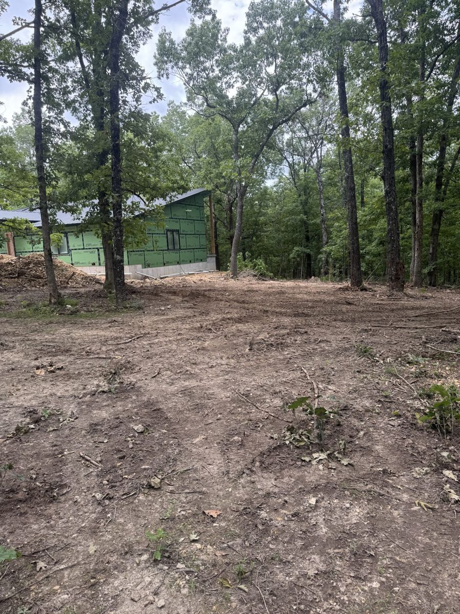 The same home site cleared to bare ground with trees left standing
